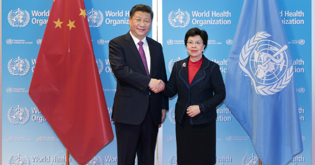 中国国家主席习近平与世卫组织总干事陈冯富珍在中国国旗和世卫组织旗帜前亲切握手